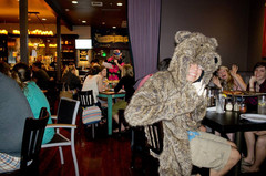 Guy wearing a bear coat in a restaurant with friends.